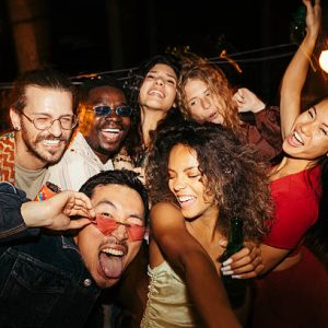 A group of multiracial friends has a great time at the roof nightclub in the summertime. Clubbing, fun, and parties during the summer concept.